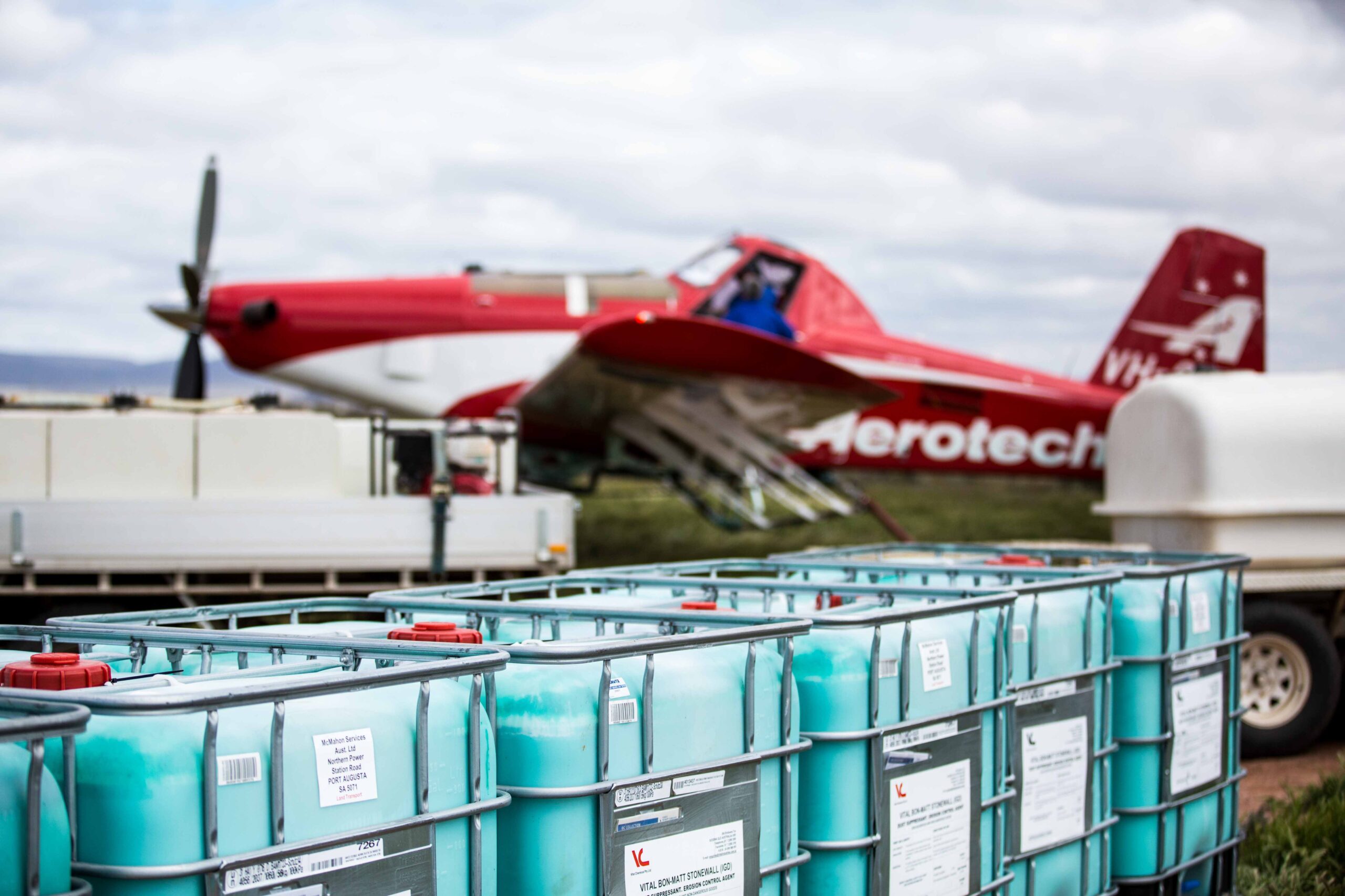 A red plane with barrels ready to be loaded