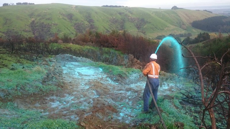 Worker applying revegetation chemicals