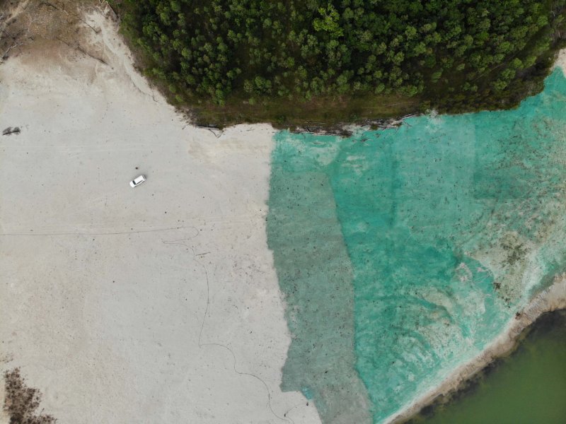 Aerial shot of chemical application to a dam.